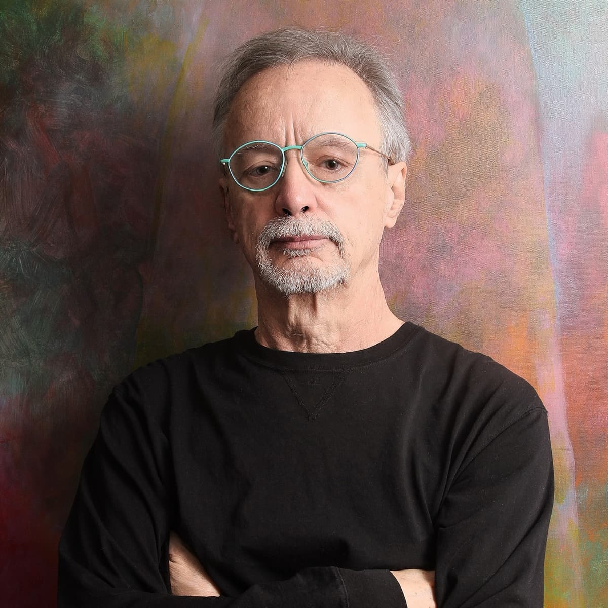 John Sandbach, standing before one of his paintings
